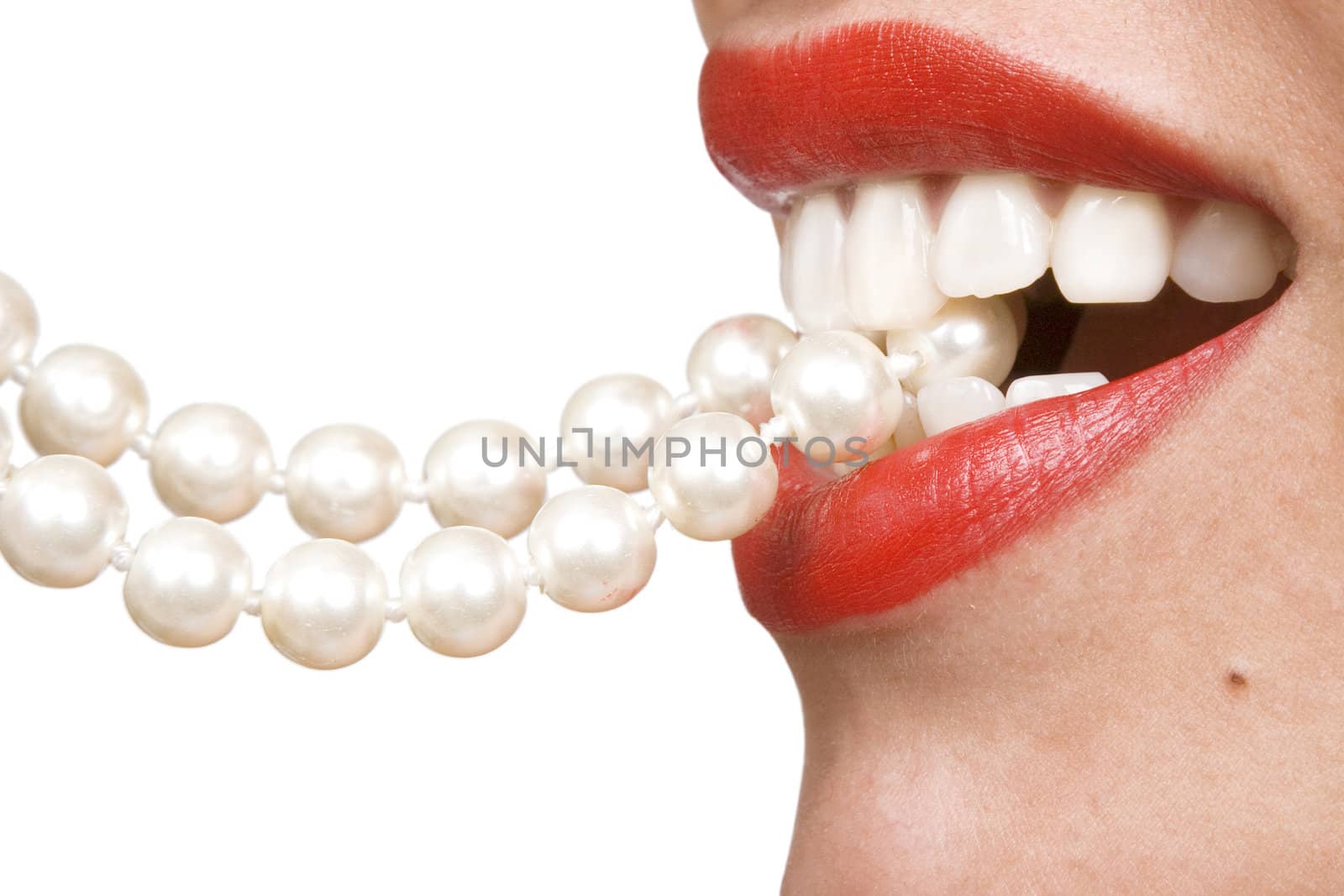 woman smiles showing white teeth, holding a pearly necklace in to the mouth, teeth care concept