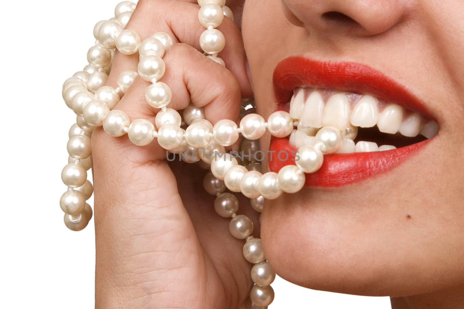 woman smiles showing white teeth, holding a pearly necklace in to the mouth, teeth care concept