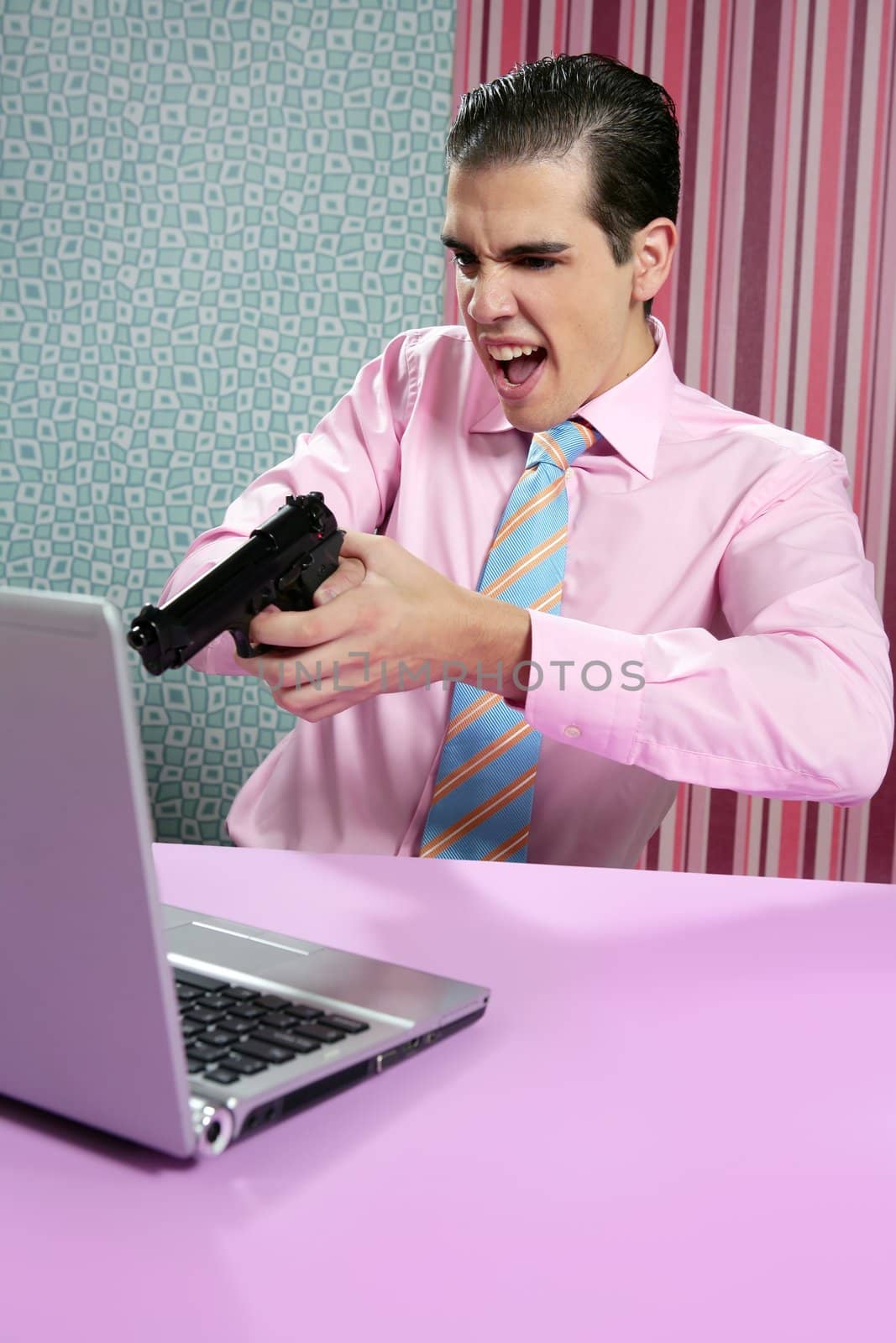 businessman young shooting handgun with computer pink bacground