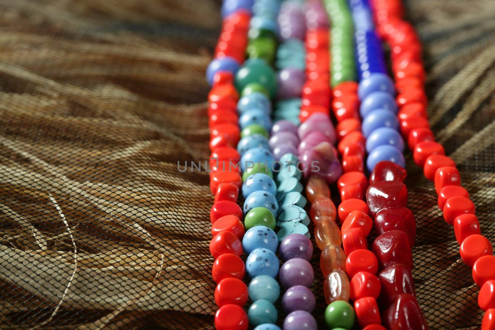 Color stones jewelry necklaces, straw background by lunamarina