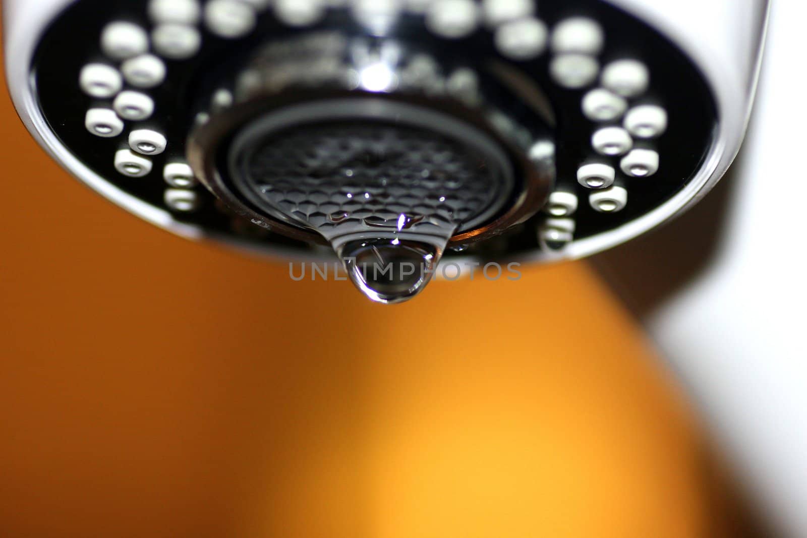 A macro of a white tap / faucet dripping.