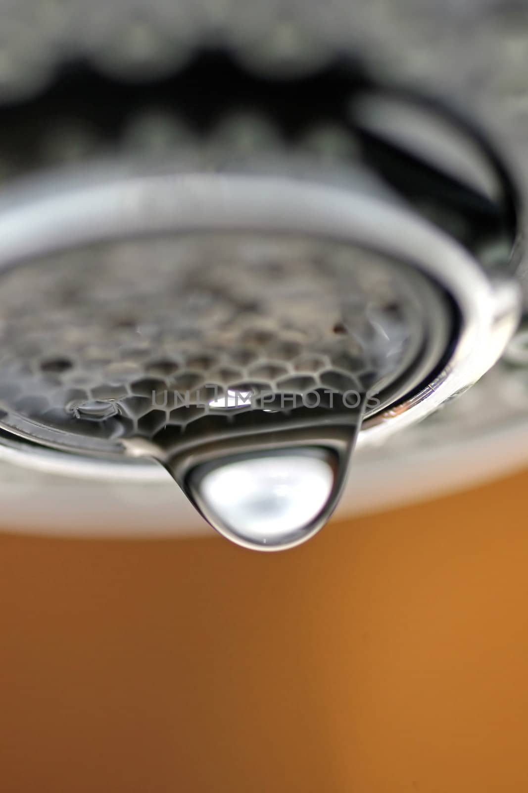 A macro of a white tap / faucet dripping.