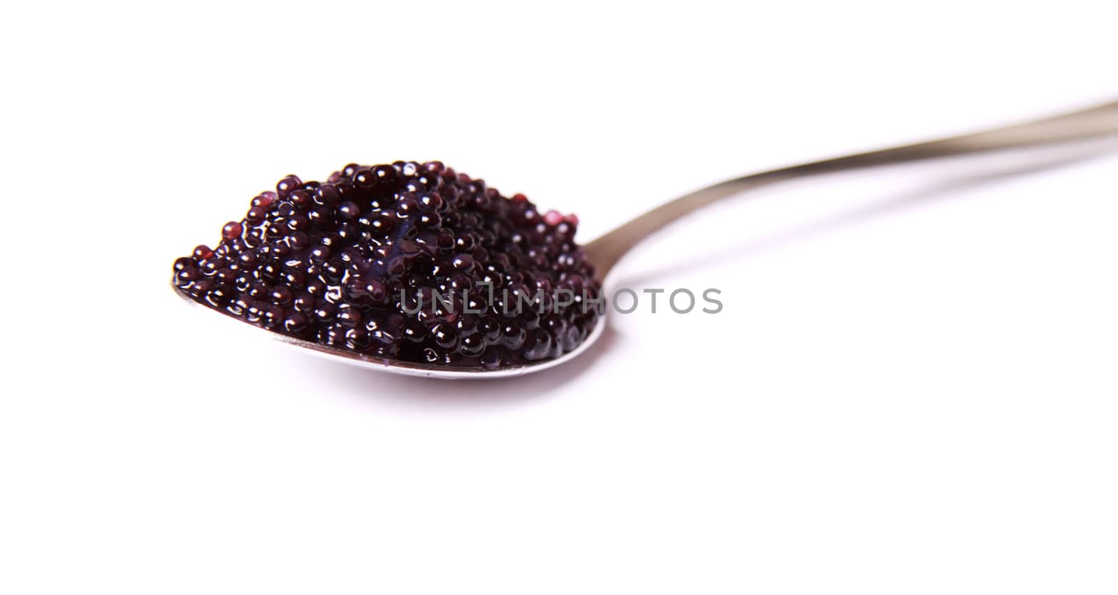 Black caviar on a spoon on a white background