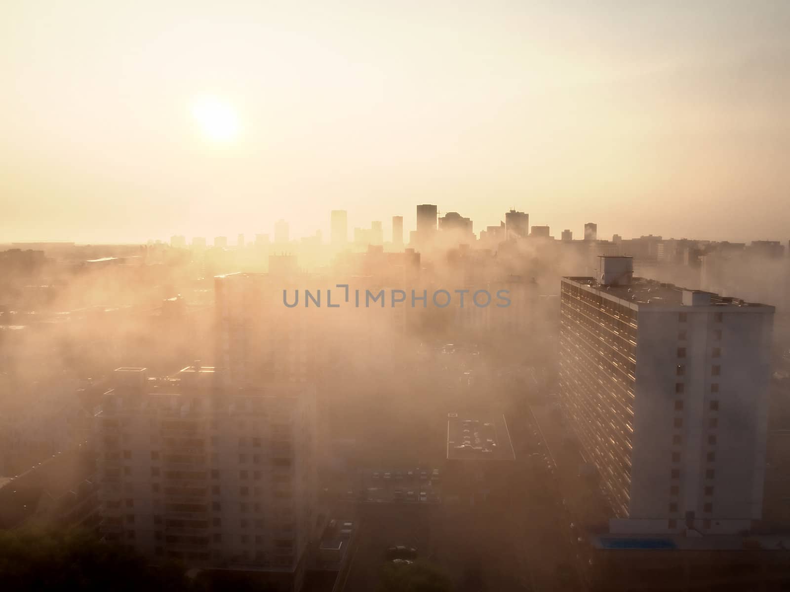 Brilliant sunrise cutting through the fog that covers the city.