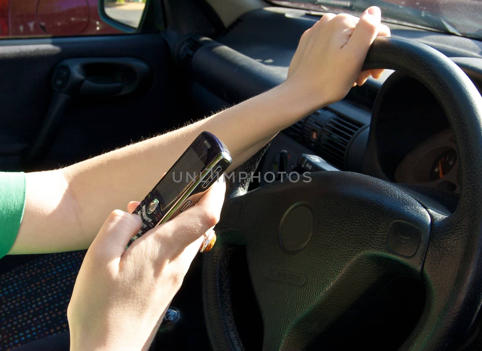Woman sending a text message while driving a car.