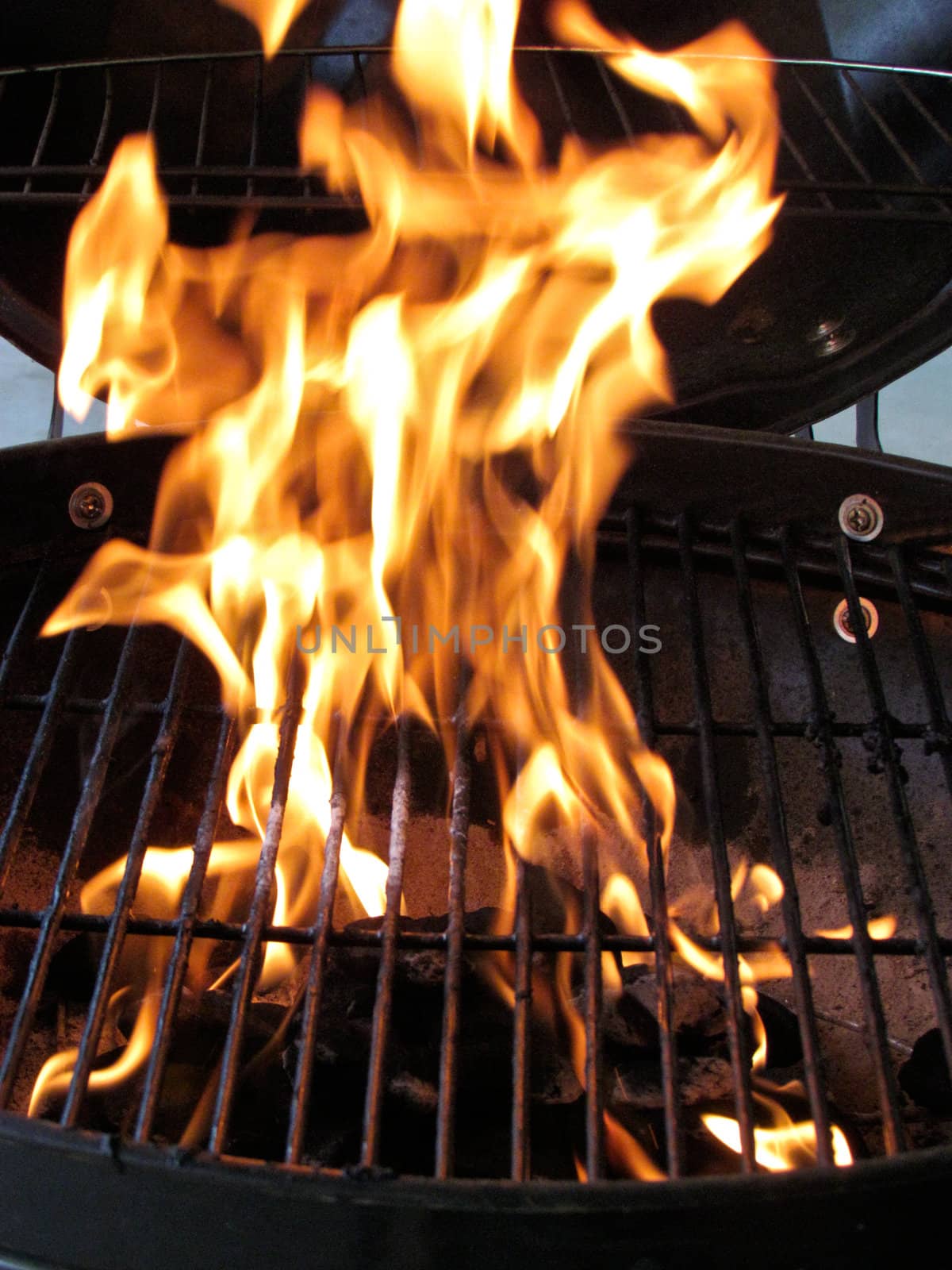 Close up of a newly lit BBQ grill with tall flames.