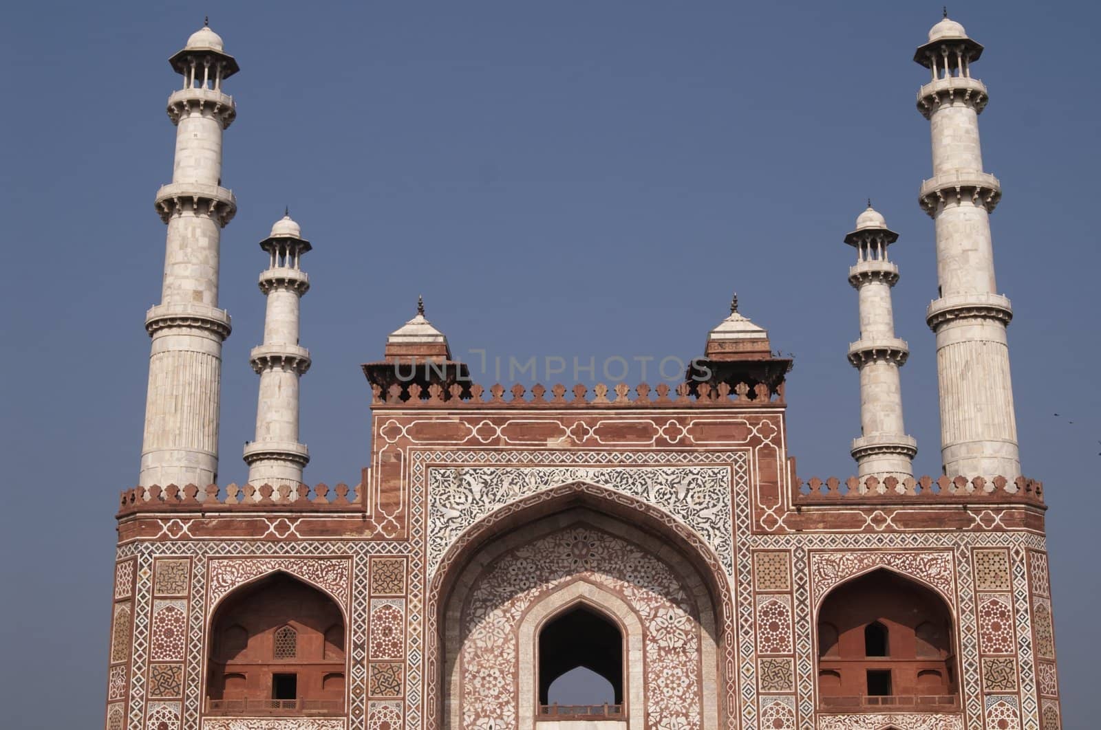 Ornate entrance to Akbar's Tomb. Islamic style architecture. Red sandstone building inlaid with white marble with marble minarets at each corner. Sikandra, Agra, India