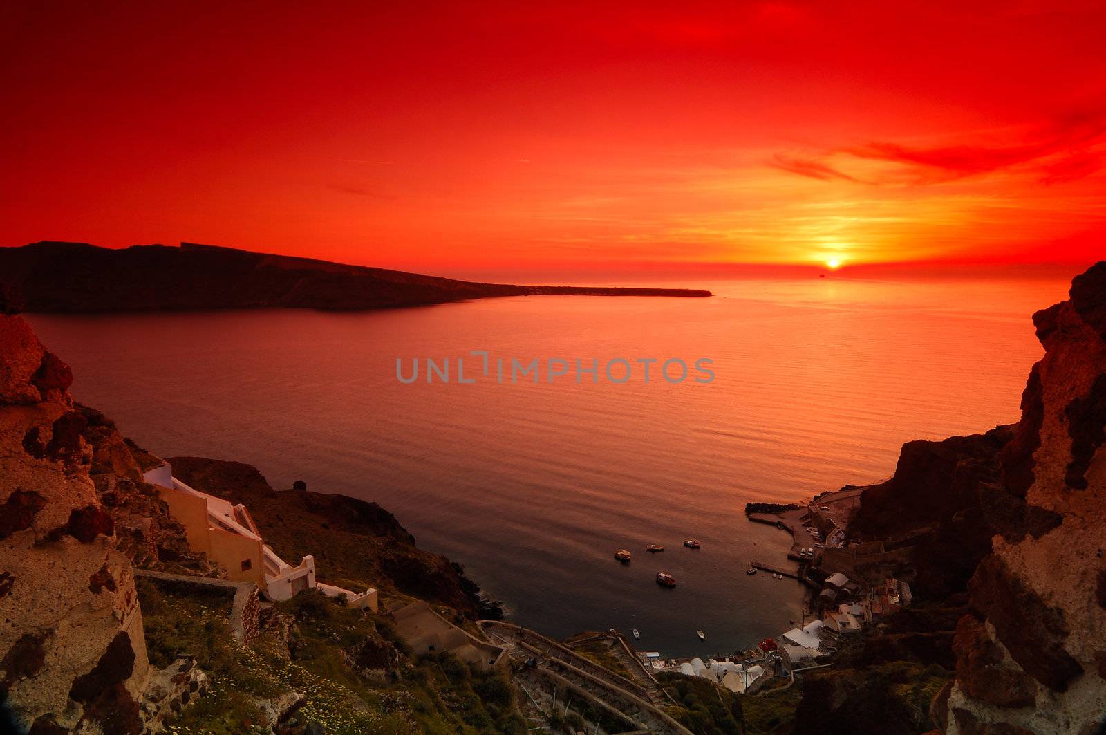 Image shows a spectacular sunset in the village of Oia, Santorini, Greece