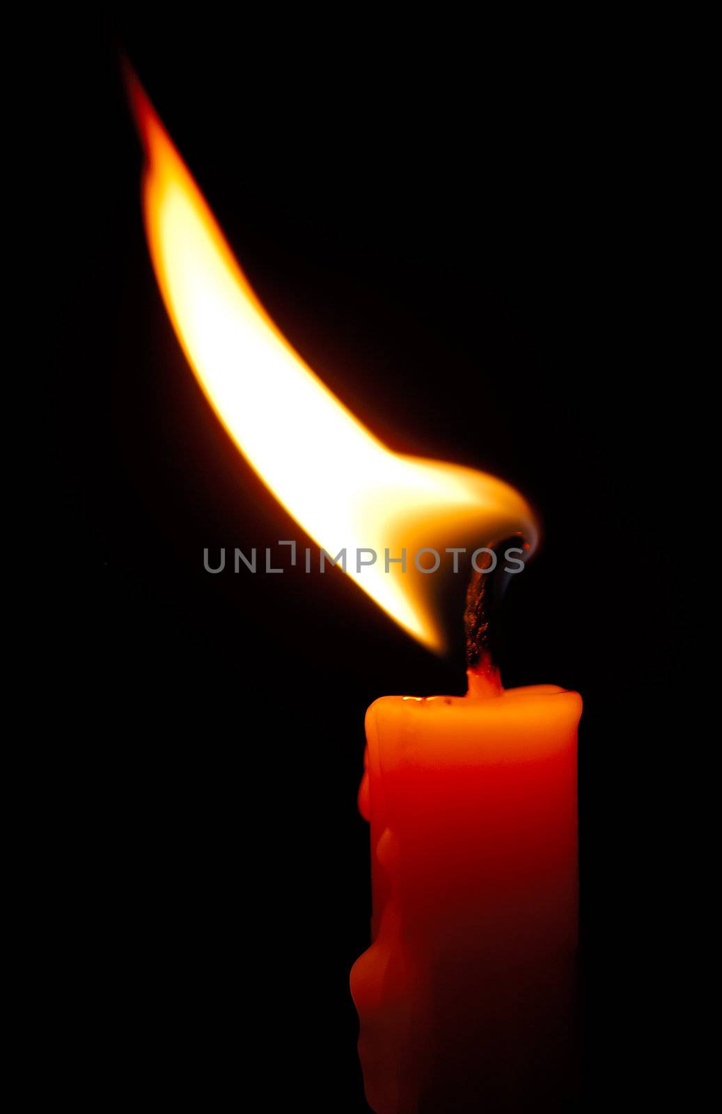 Image shows a red candle with a shimmering flame