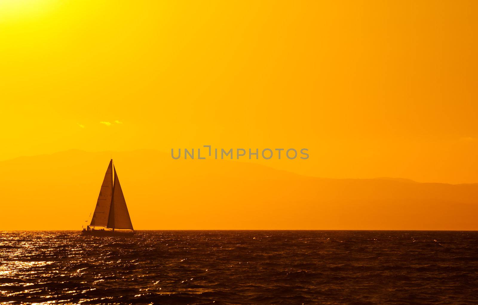 A sailing boat travelling the Mediterranean late in the afternoon