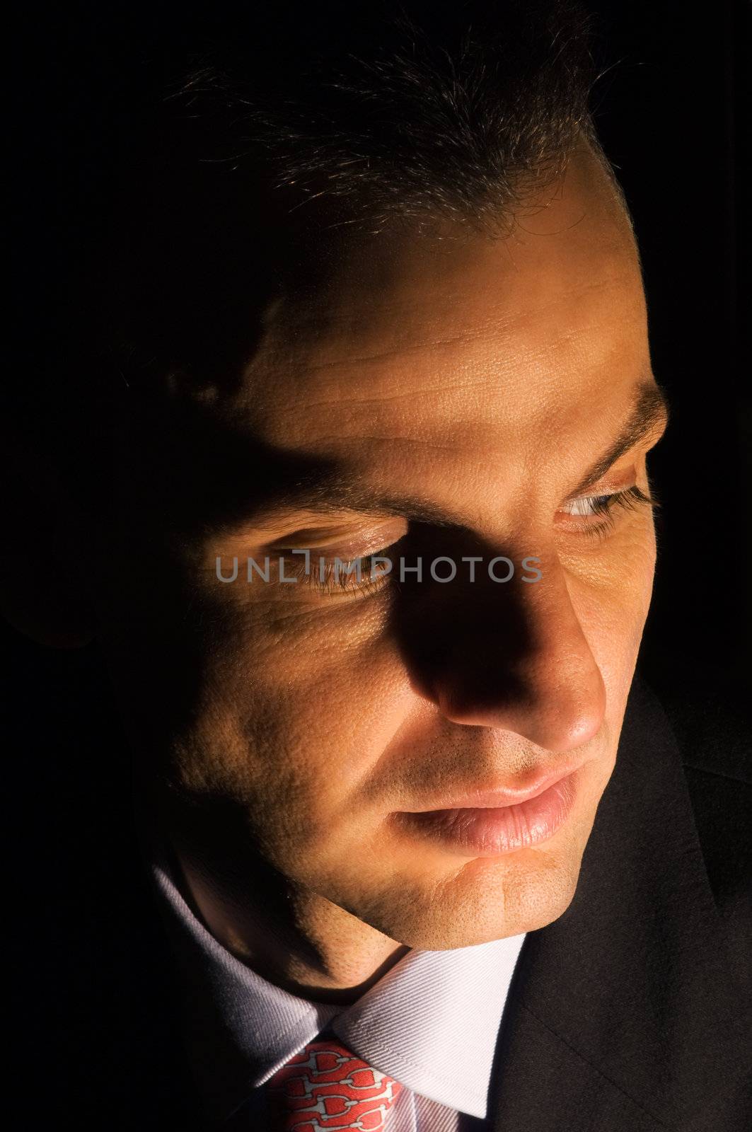 Portrait of a young businessman under dramatic lighting