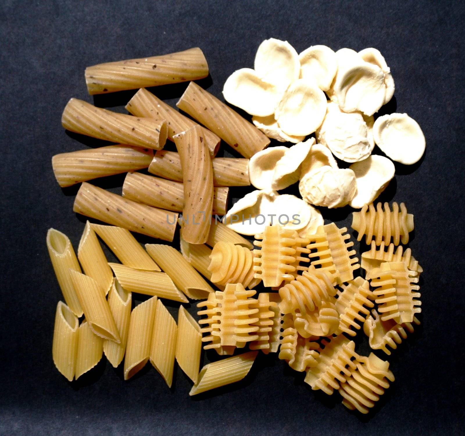 Variety of Italian pasta on black background