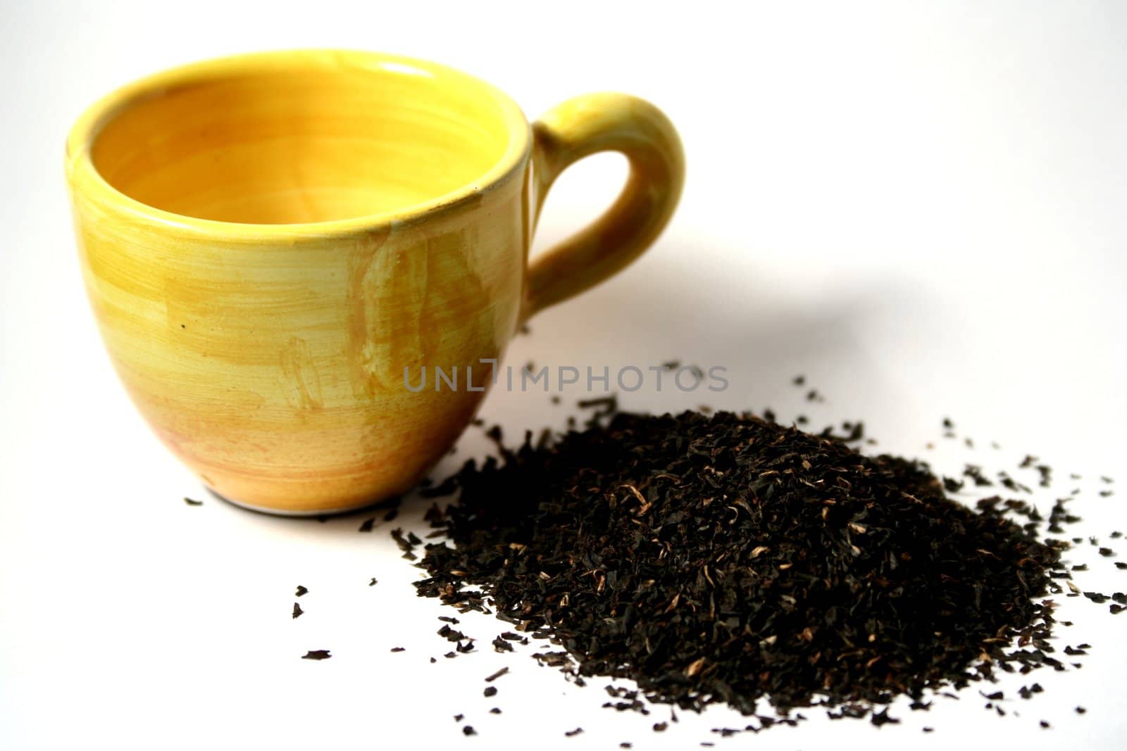 Yellow cup and black tea on white background