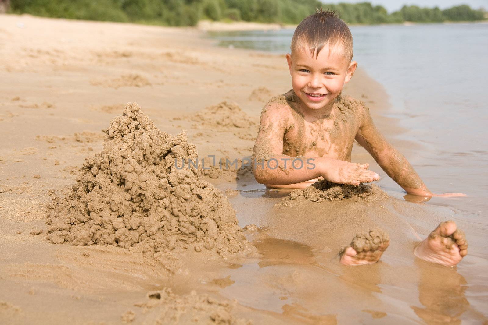 Boy on the beach digging himself