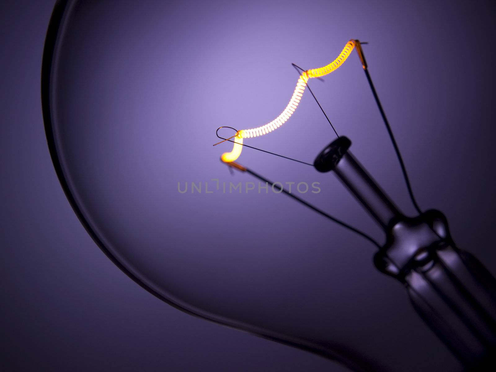 Close up on a transparent light bulb over a purple background.