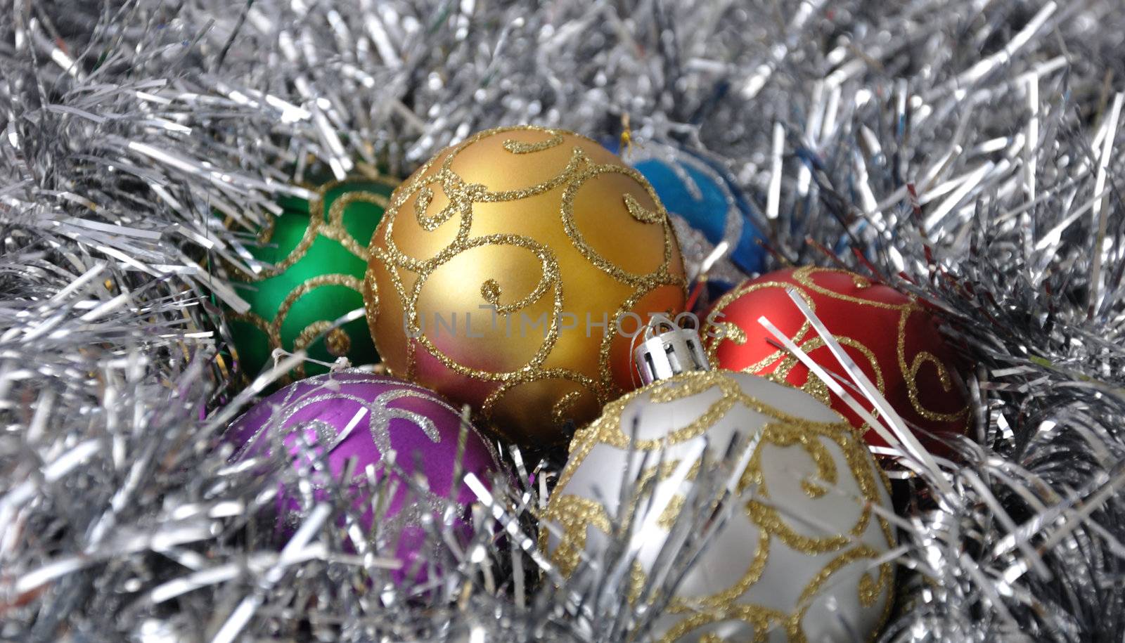 Christmas balls against the backdrop of tinsel with pine branches and cones