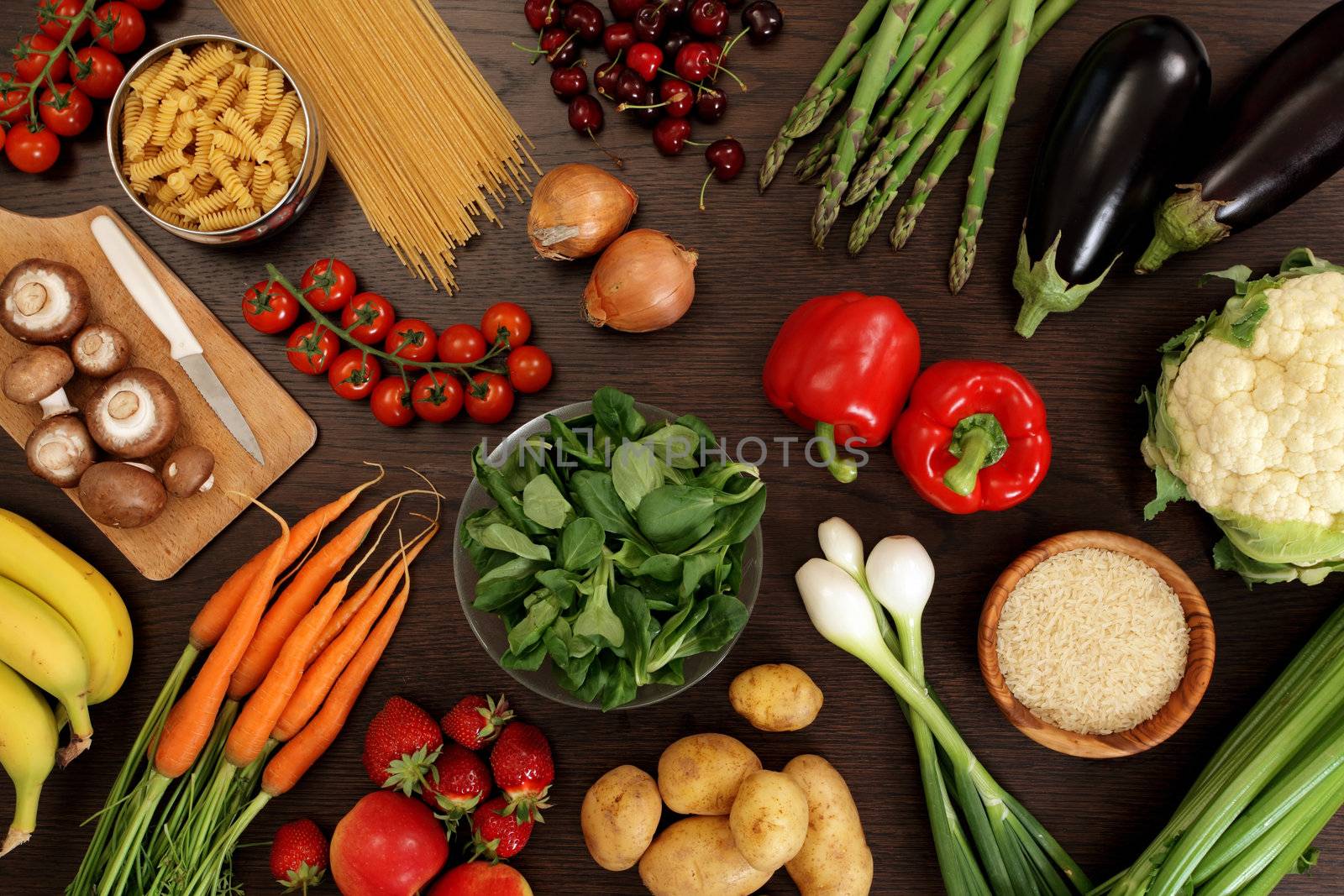 Photo of a table top full of fresh vegetables, fruit, and other healthy foods.