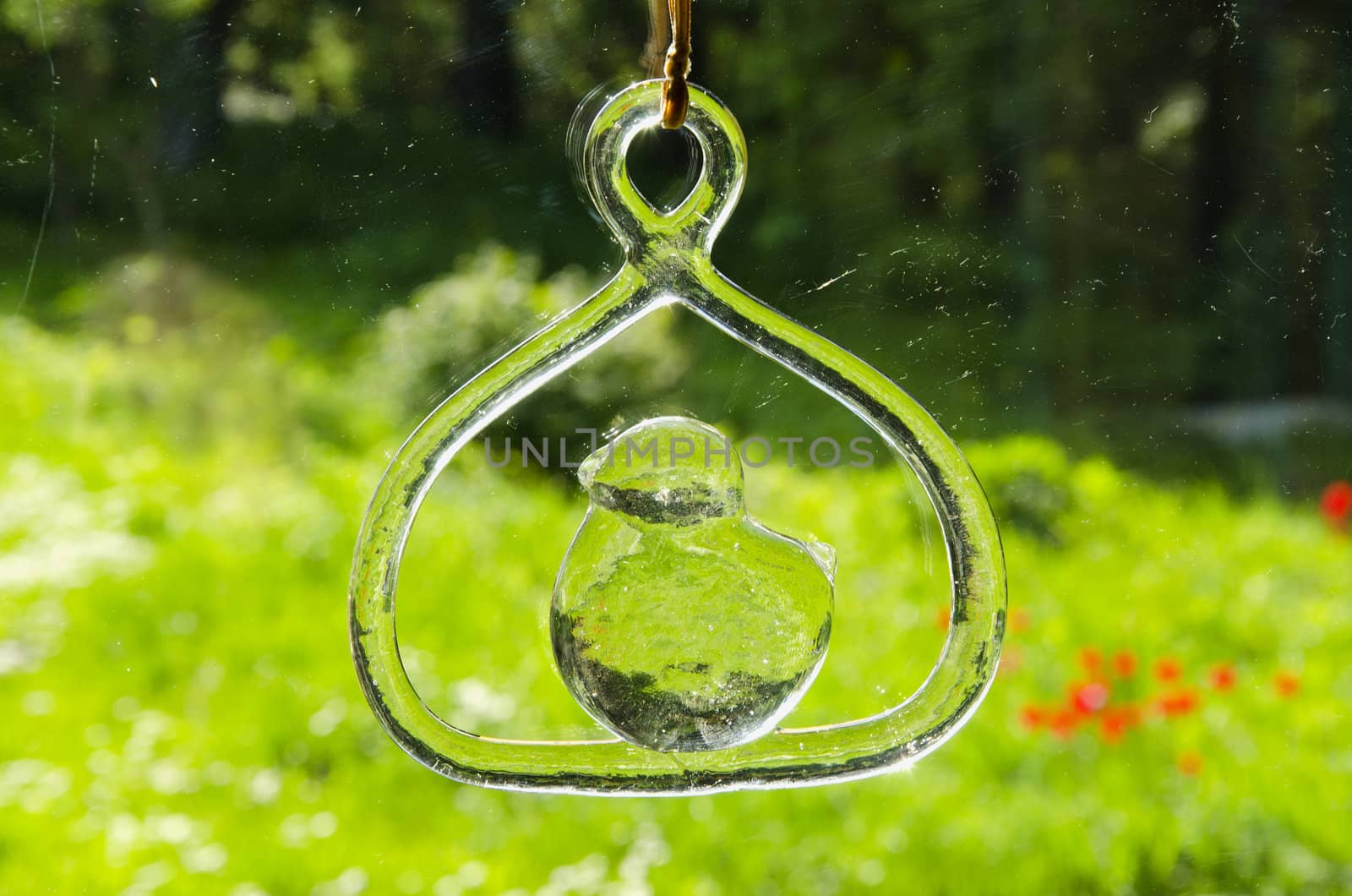 Beautiful glassy decoration hanging near window. Blur background.