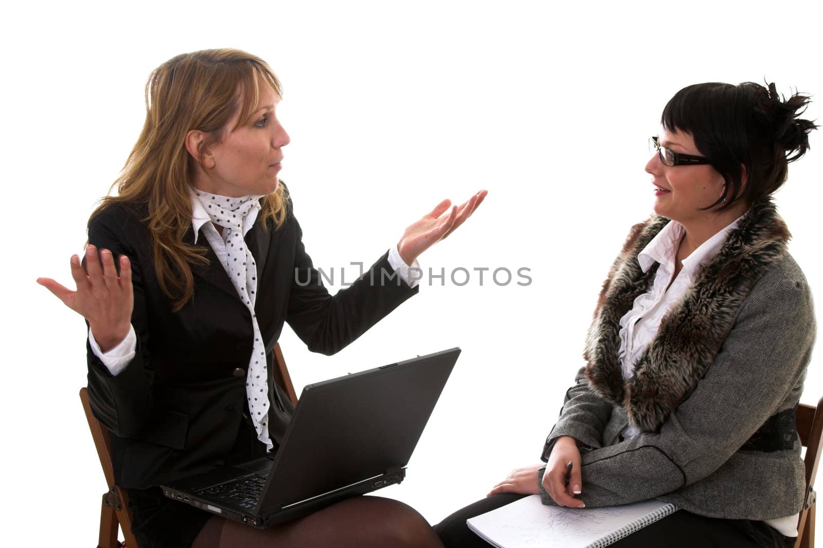 Two business women having a lively discussion on white background