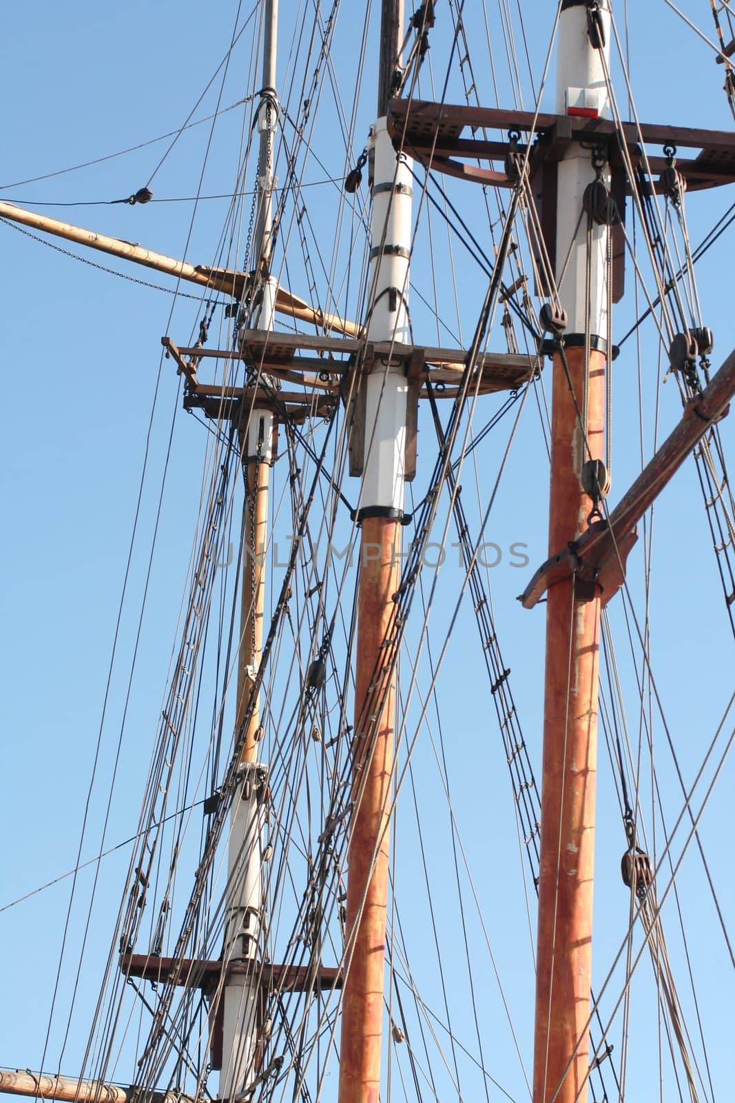 Traditional ancient wooden masts on a blue sky background