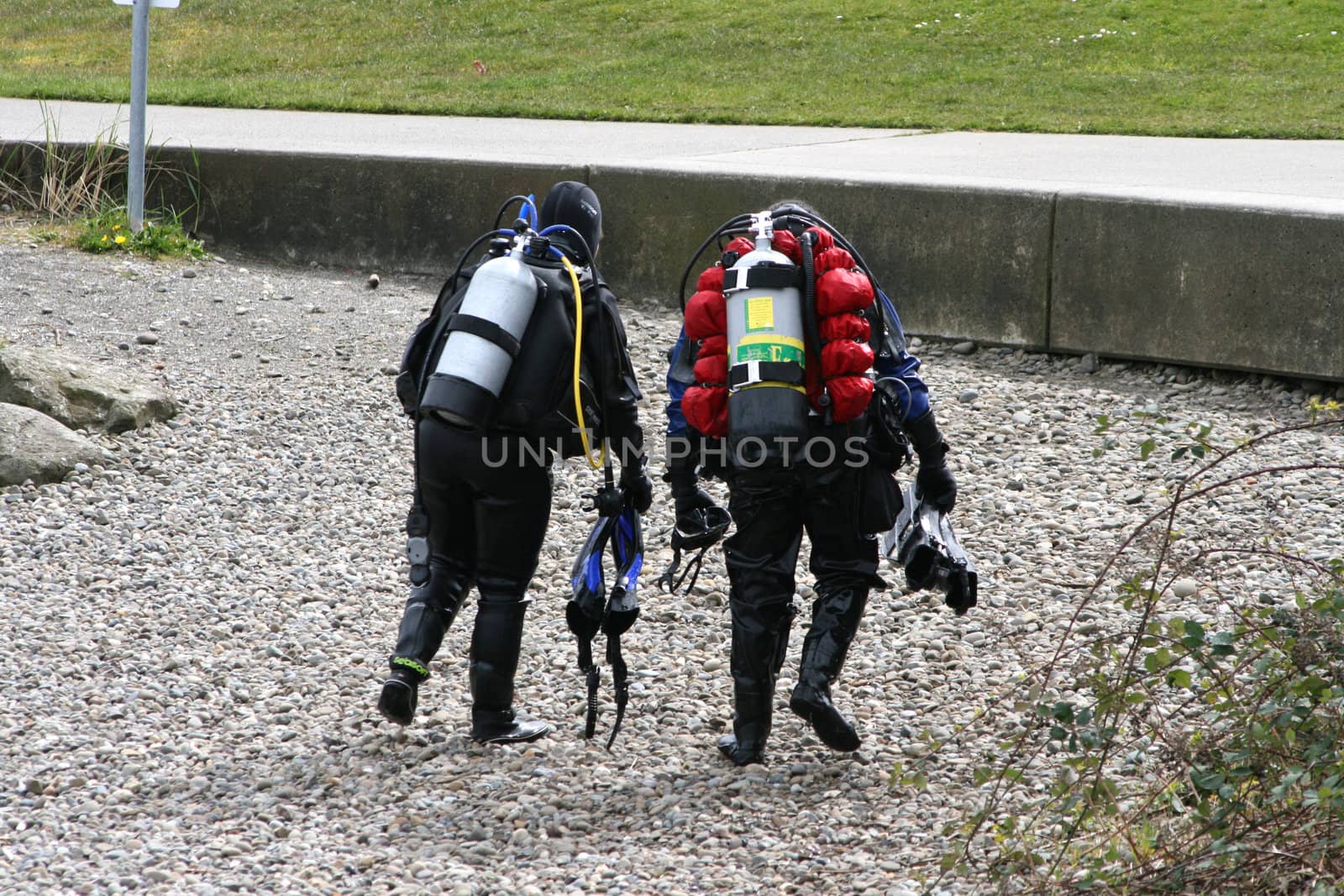 Scuba Divers is a capture of two divers that have just finished their lesson and are walking back across a rocky beach. 
