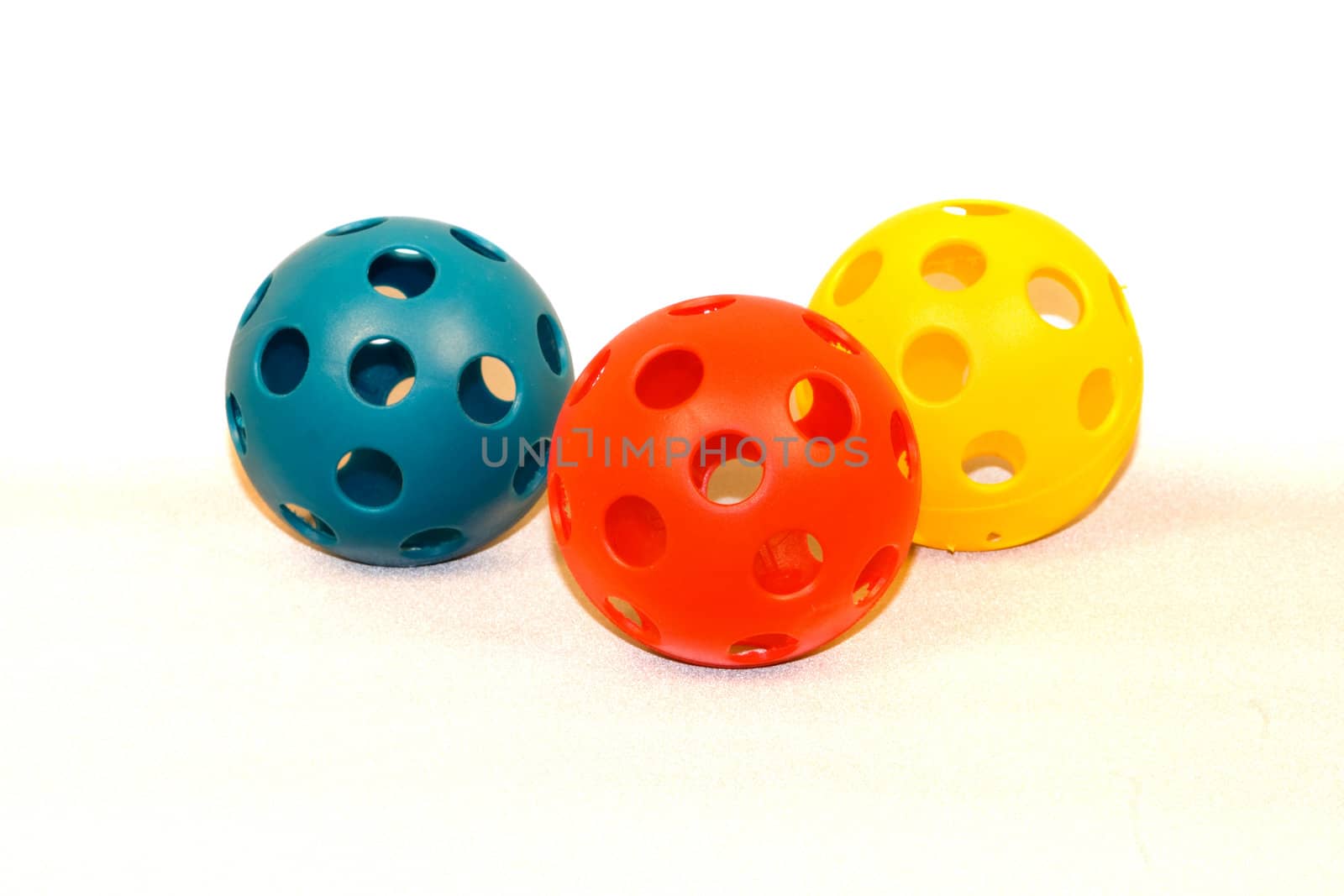 Plastic Toy Baseballs isolated in a white background with blue, yellow and red colored style practice balls for a child.
