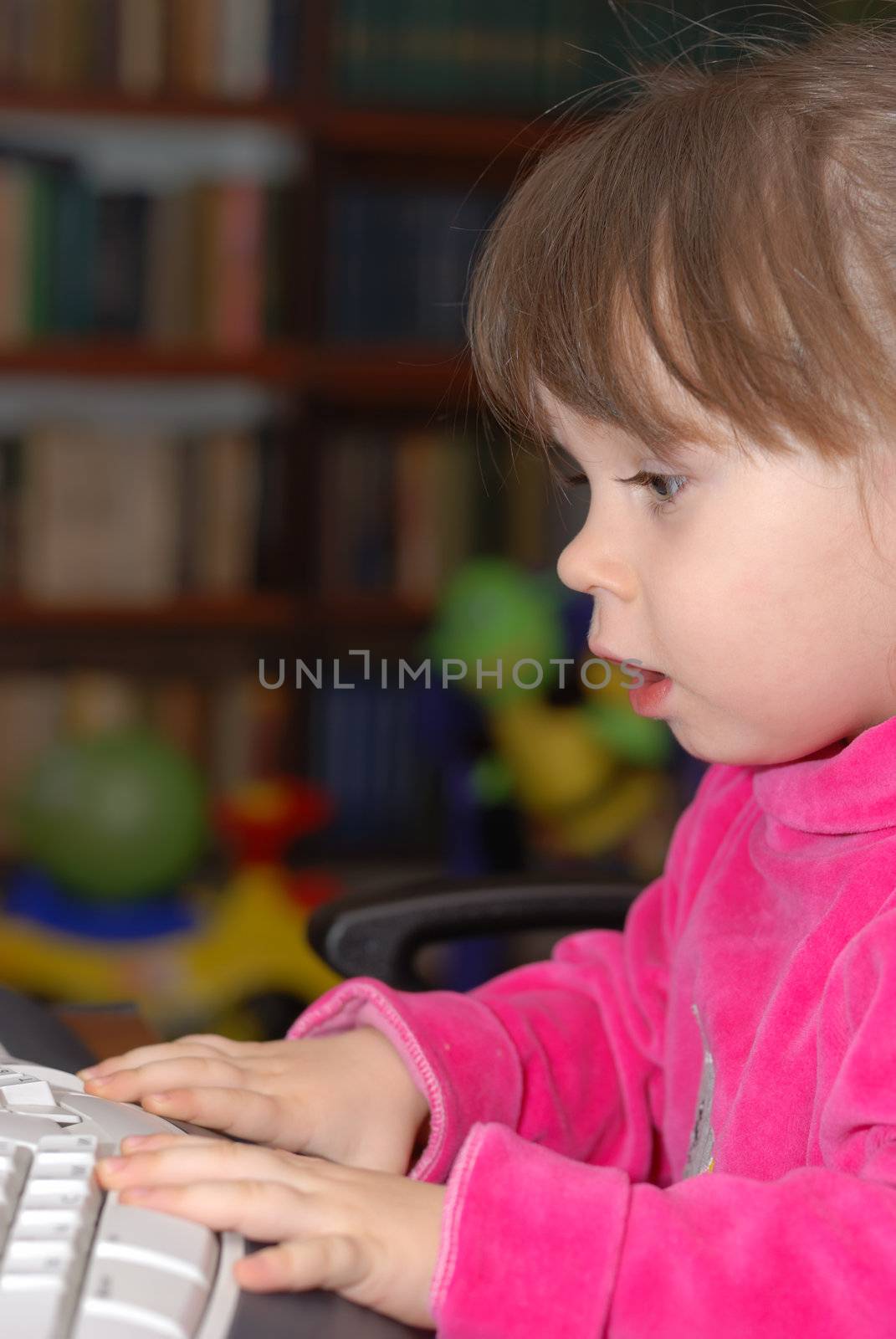 The little girl for studying keyboard of a computer