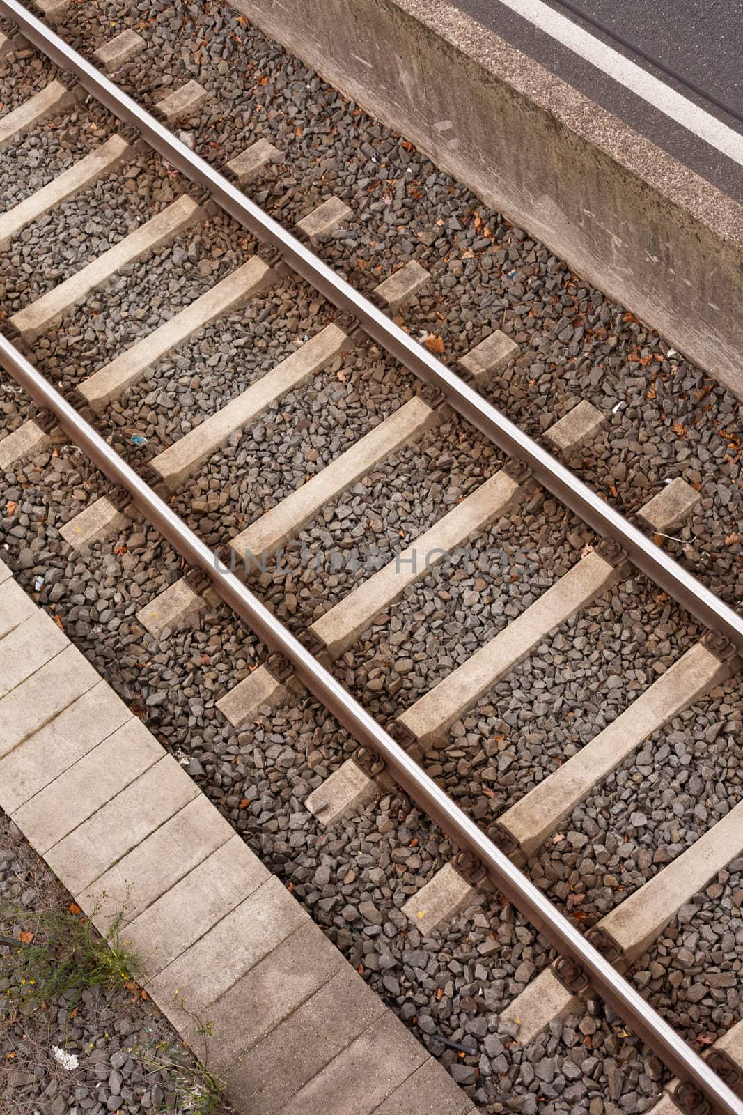 Railway track on railroad embankment of gravel and concrete.