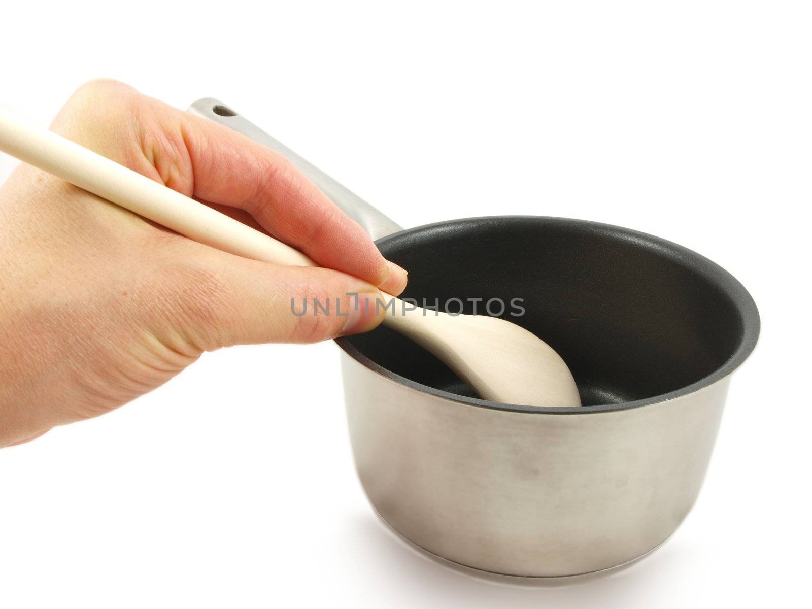 Stainless steel kettle, with wooden spatula and human hand, isolated towards white background