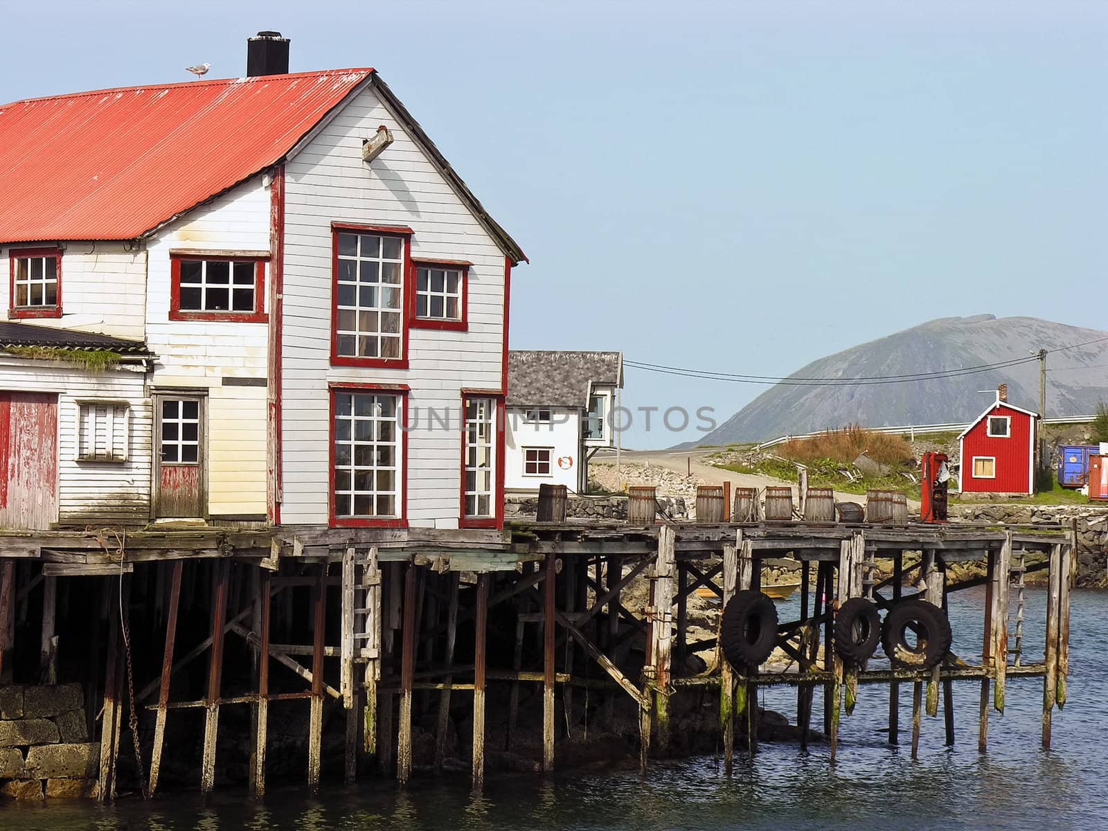 Old ruined red and white wooden nordic house over a river in Norway