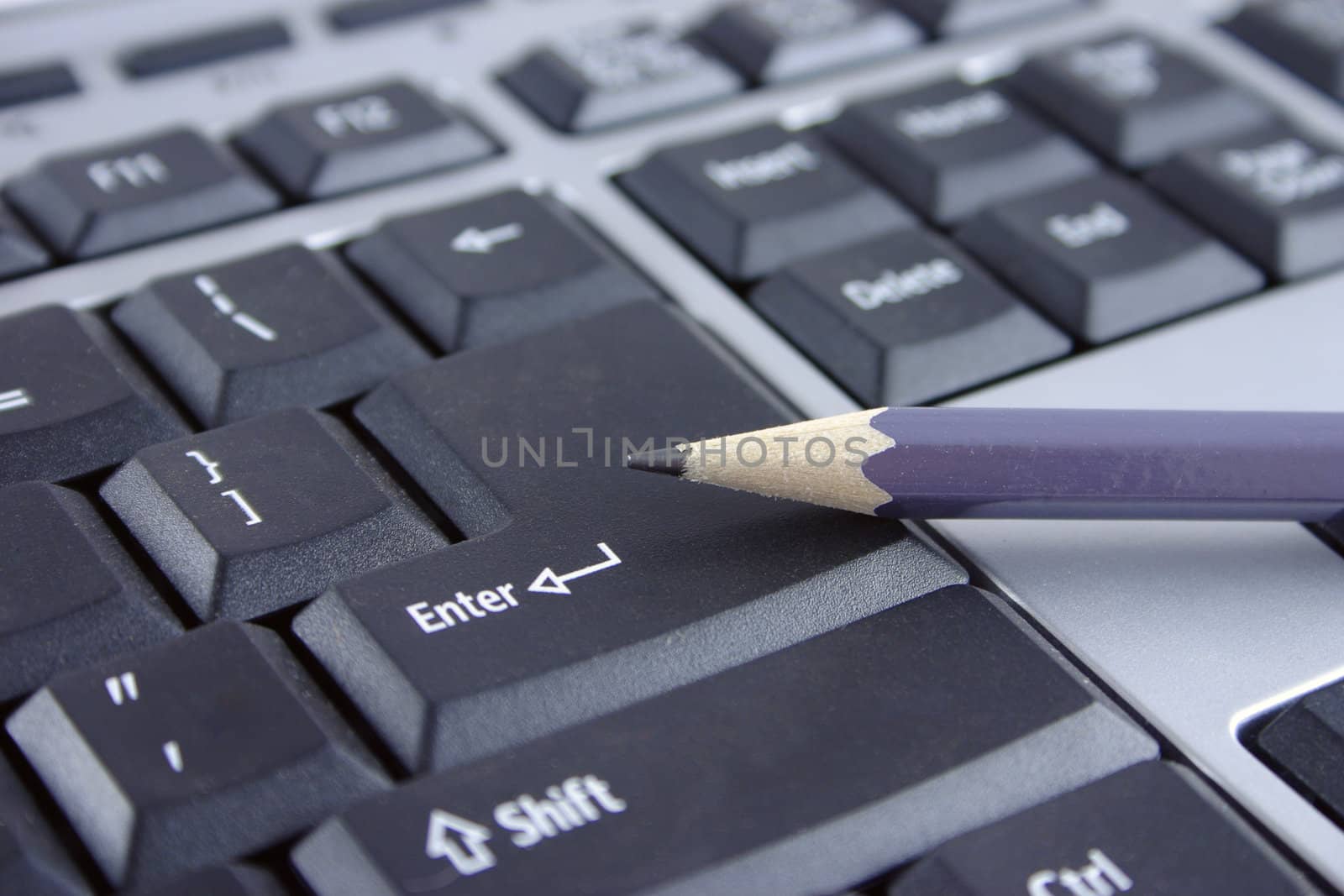 The pencil lying on a key Enter the computer keyboard