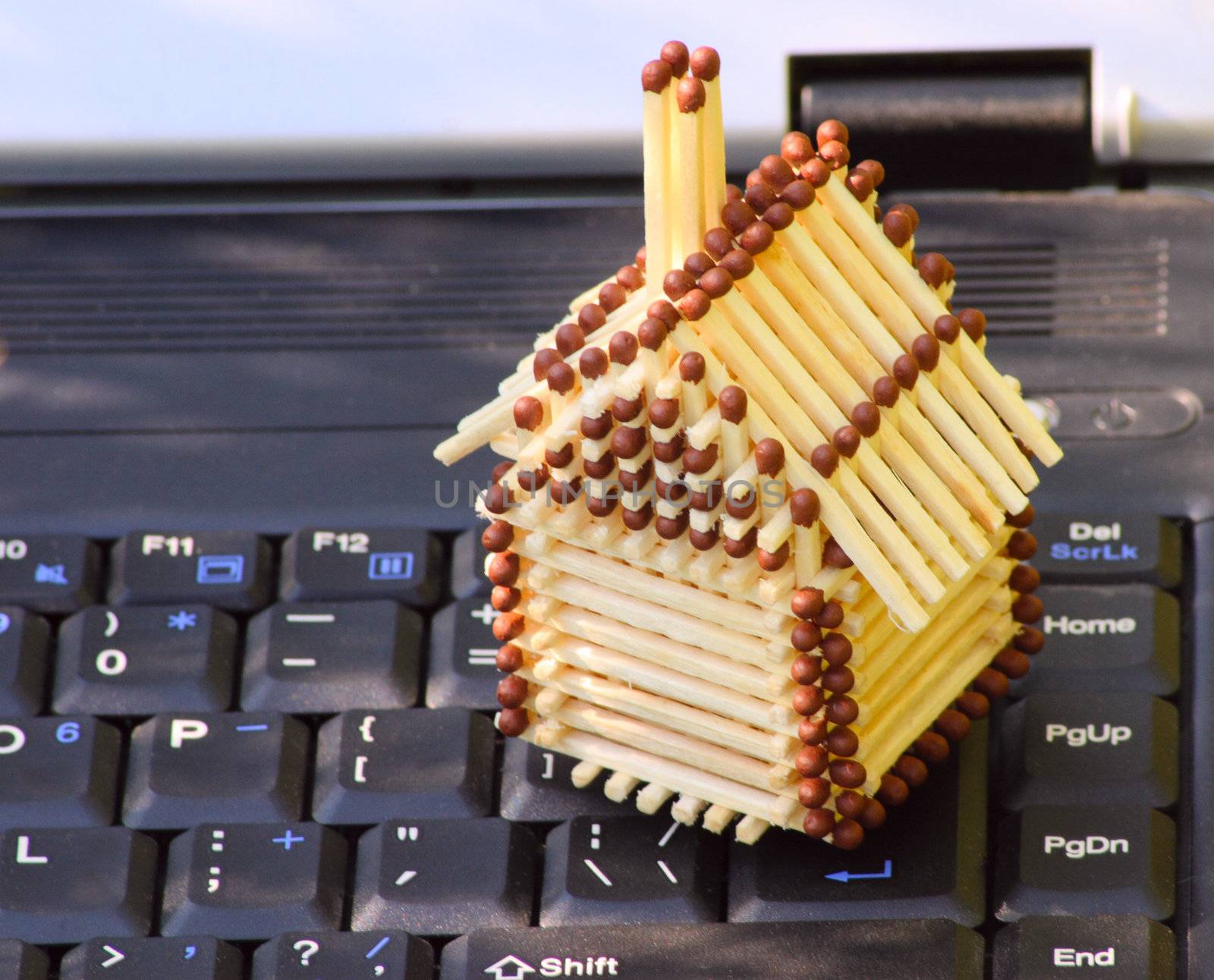The match small house standing on the keyboard of the laptop