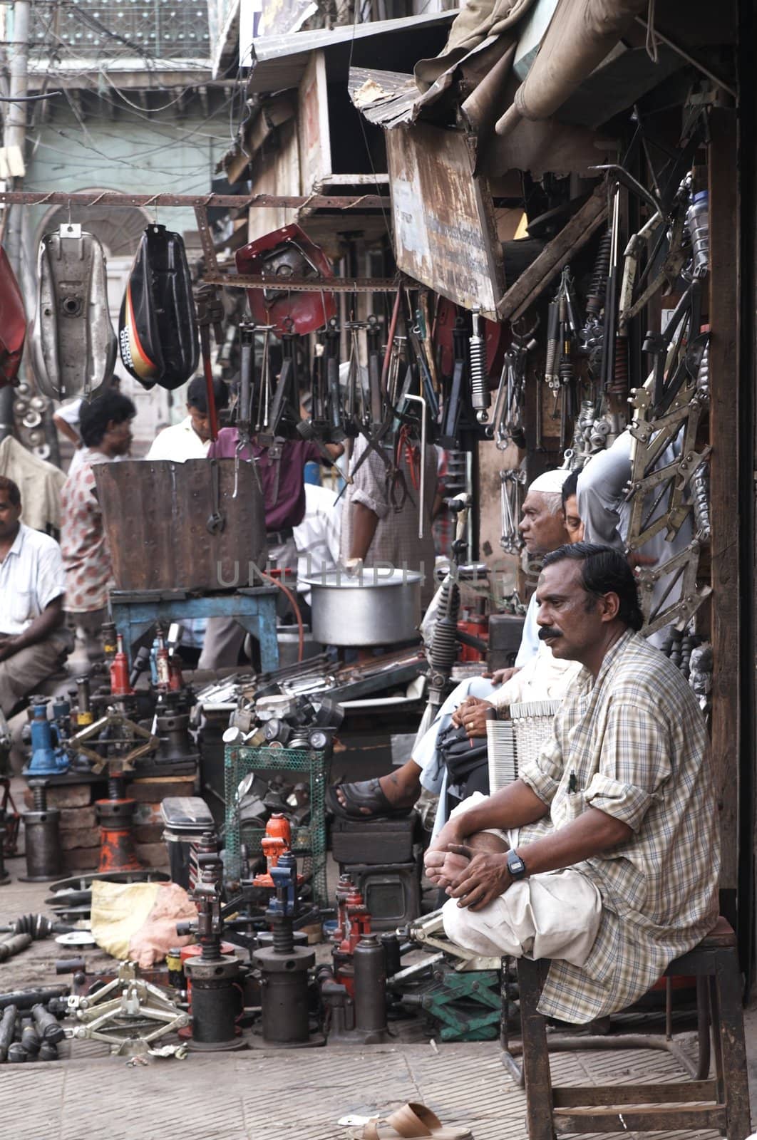 Indian man outside a shop selling car parts in Old Delhi, India