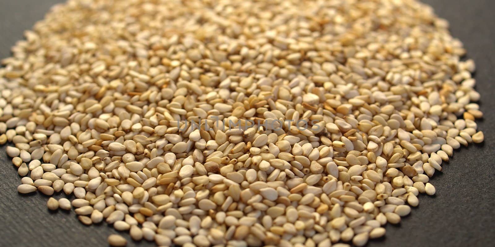 A heap of brown yellow sesame seeds