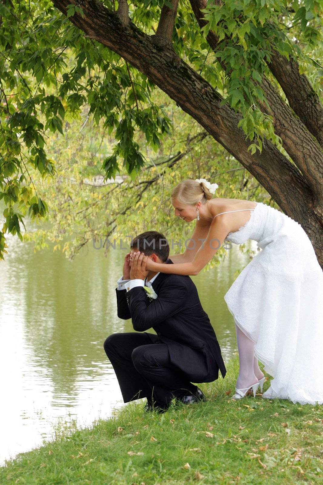 Couple romancing by side of lake, newlywed bride and groom.