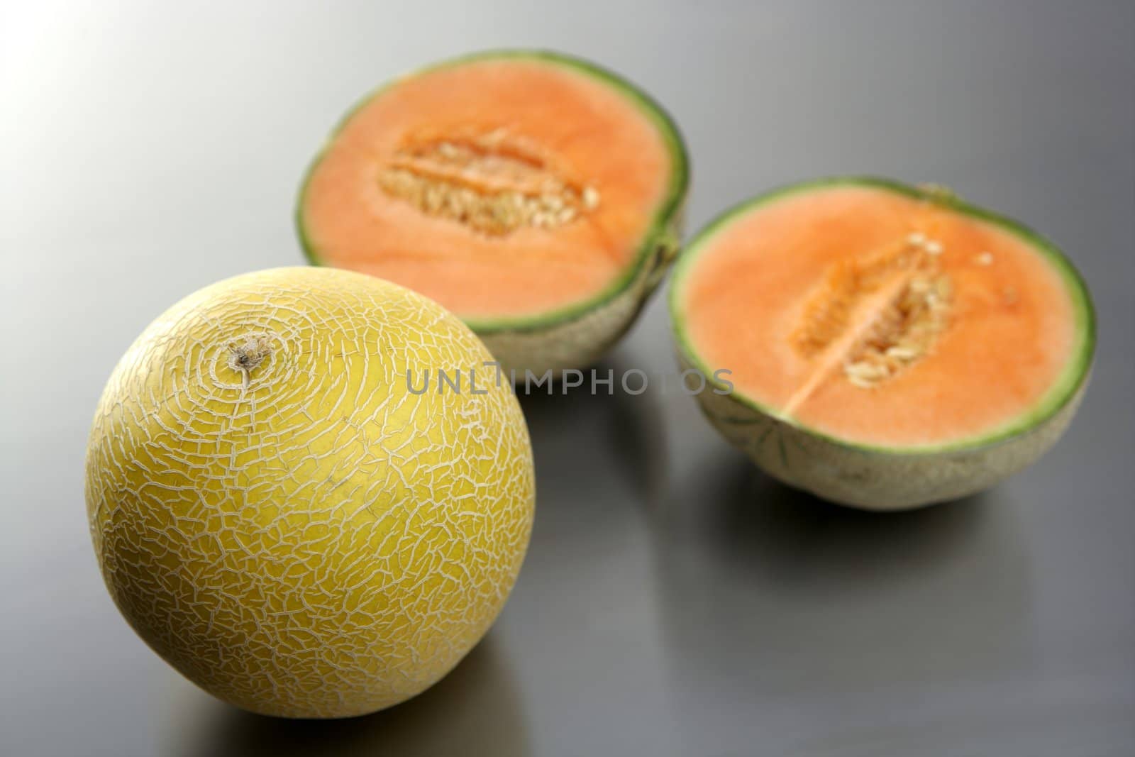 Two melon fruit over a stainless steel table