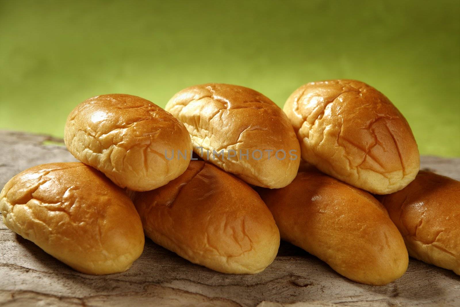 Brioche little bread stacked in two rows over green background