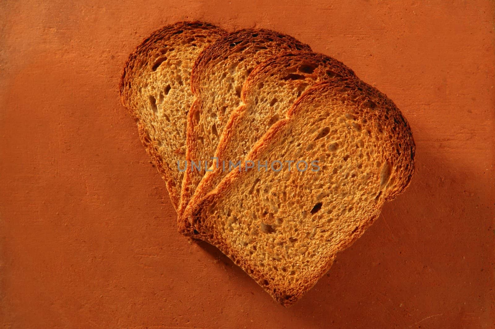 Toasted bread slices over orange clay background