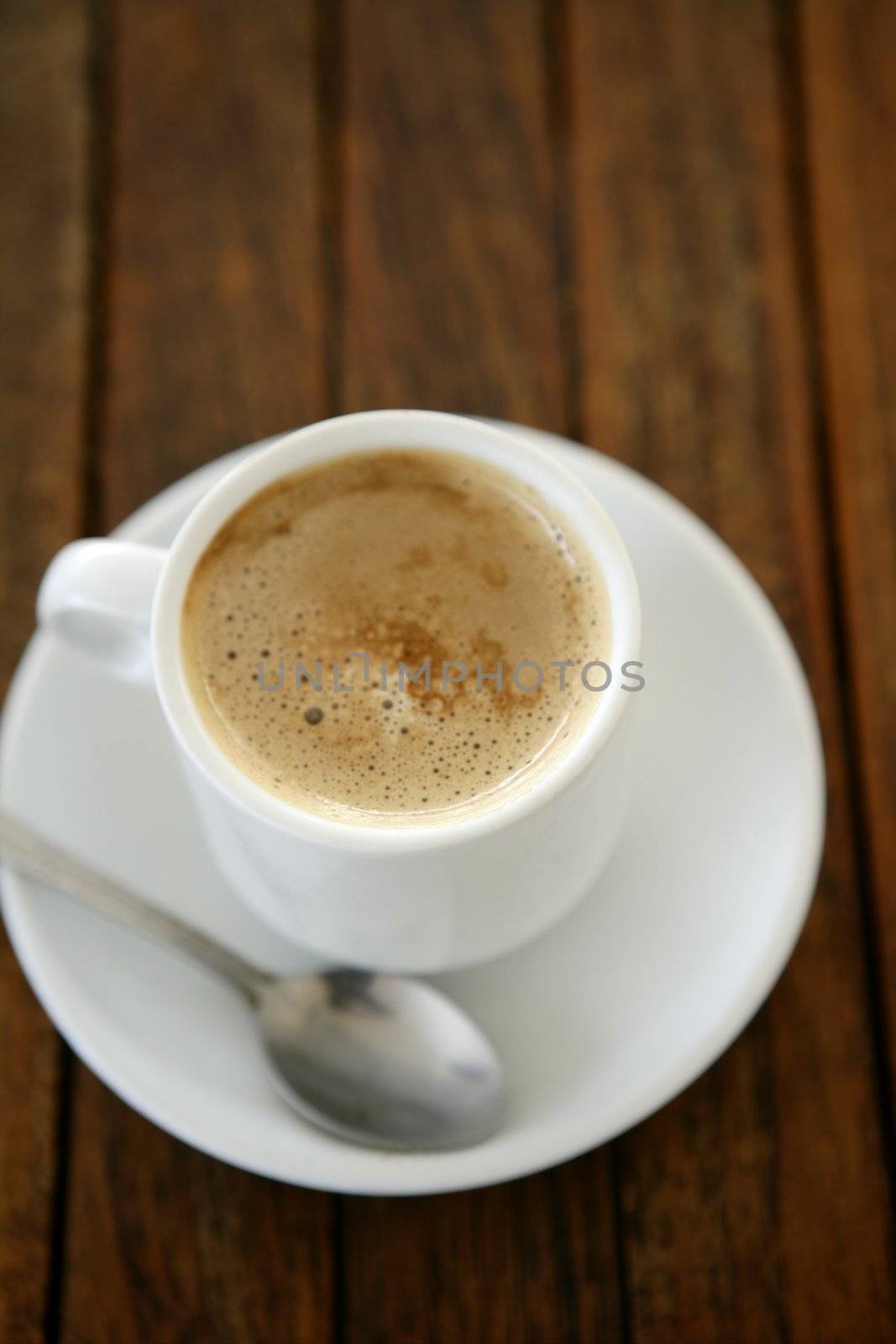Coffe with milk white cup over teak wooden background