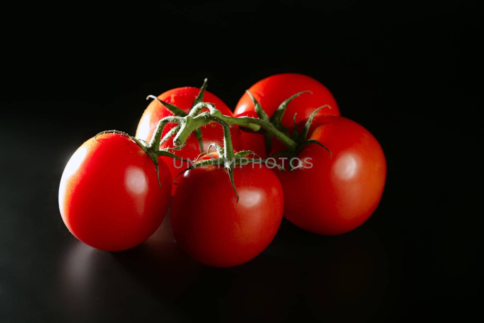 Cluster red tomato over dark black background