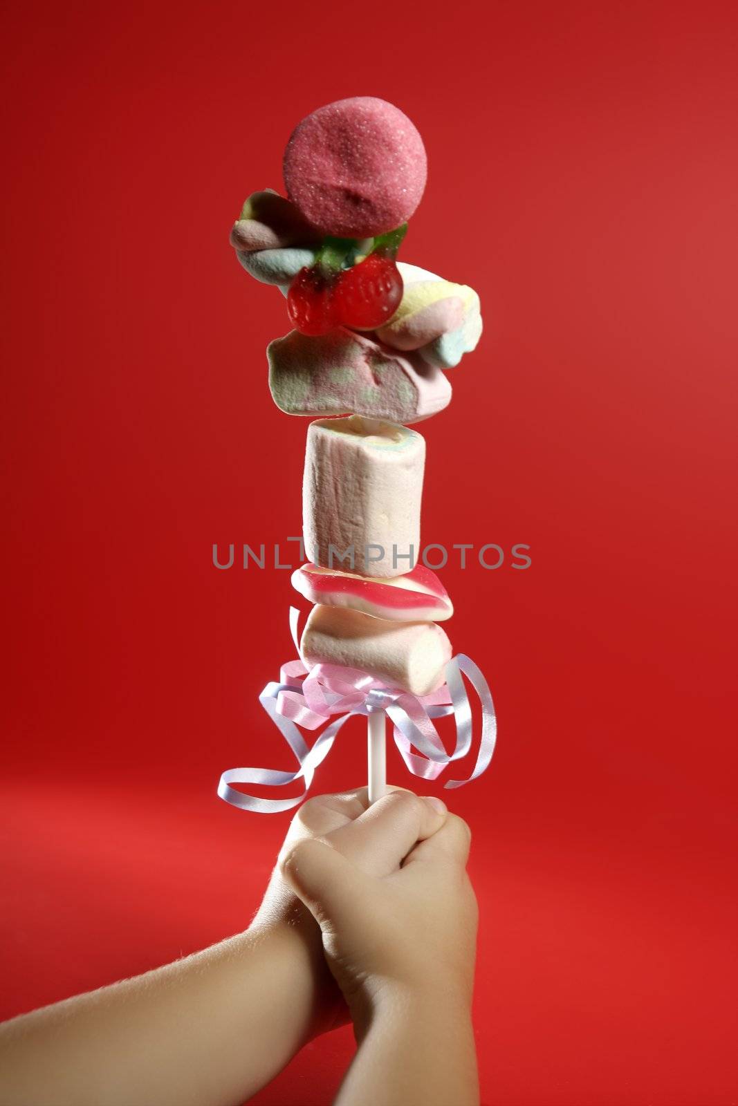 Candy colorful lollipop on child hand by lunamarina