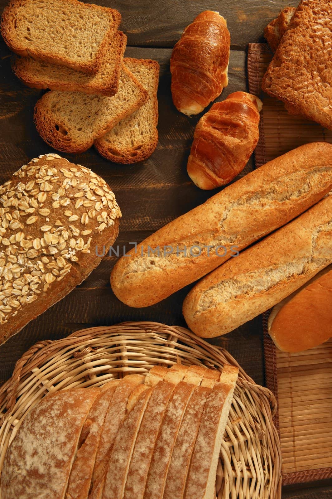 Varied bread still life over dark wood background