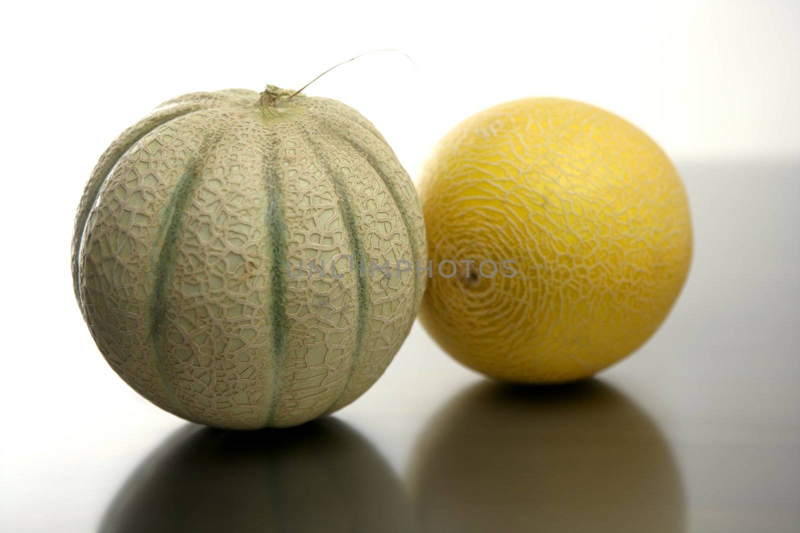Two melon fruit over a stainless steel table