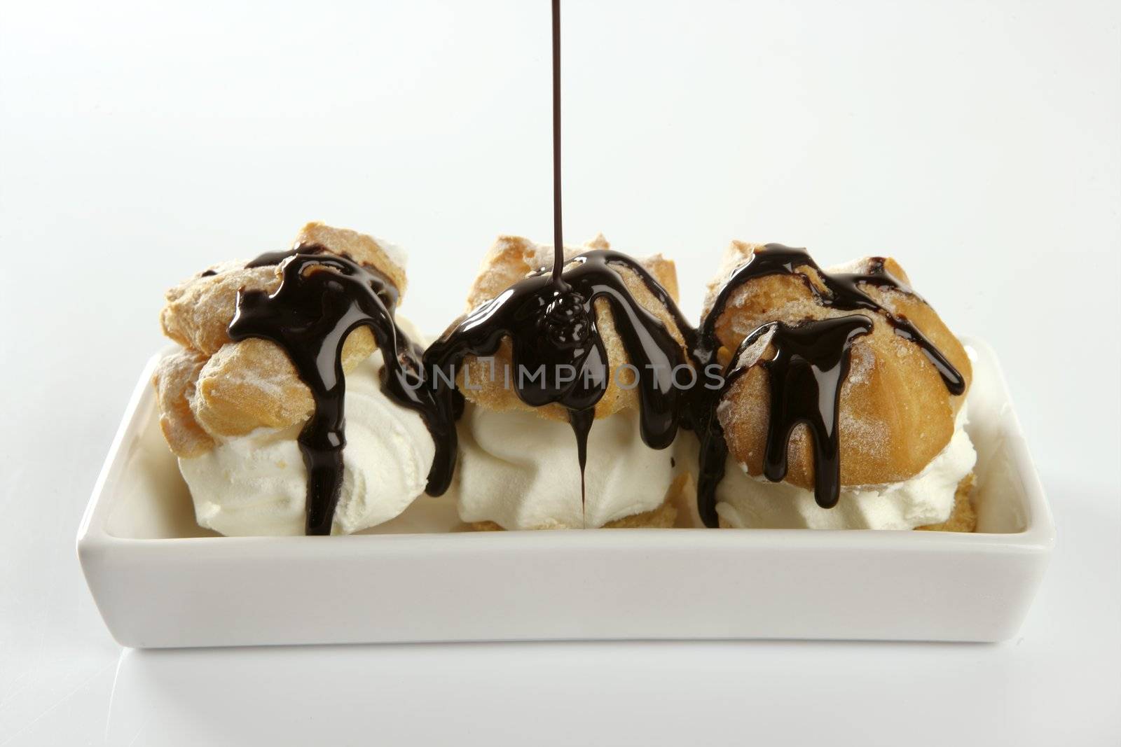 Delicious cream puff cake with chocolate syrup by lunamarina