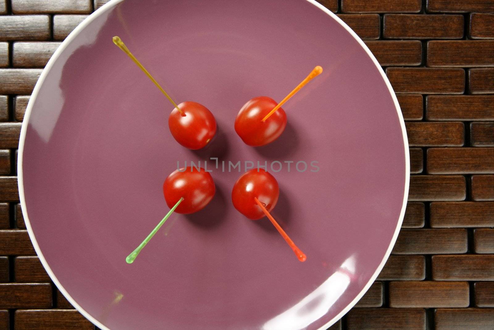 Tomatoes snack in a purple dish and colored sticks a very healthy begetables apetizer