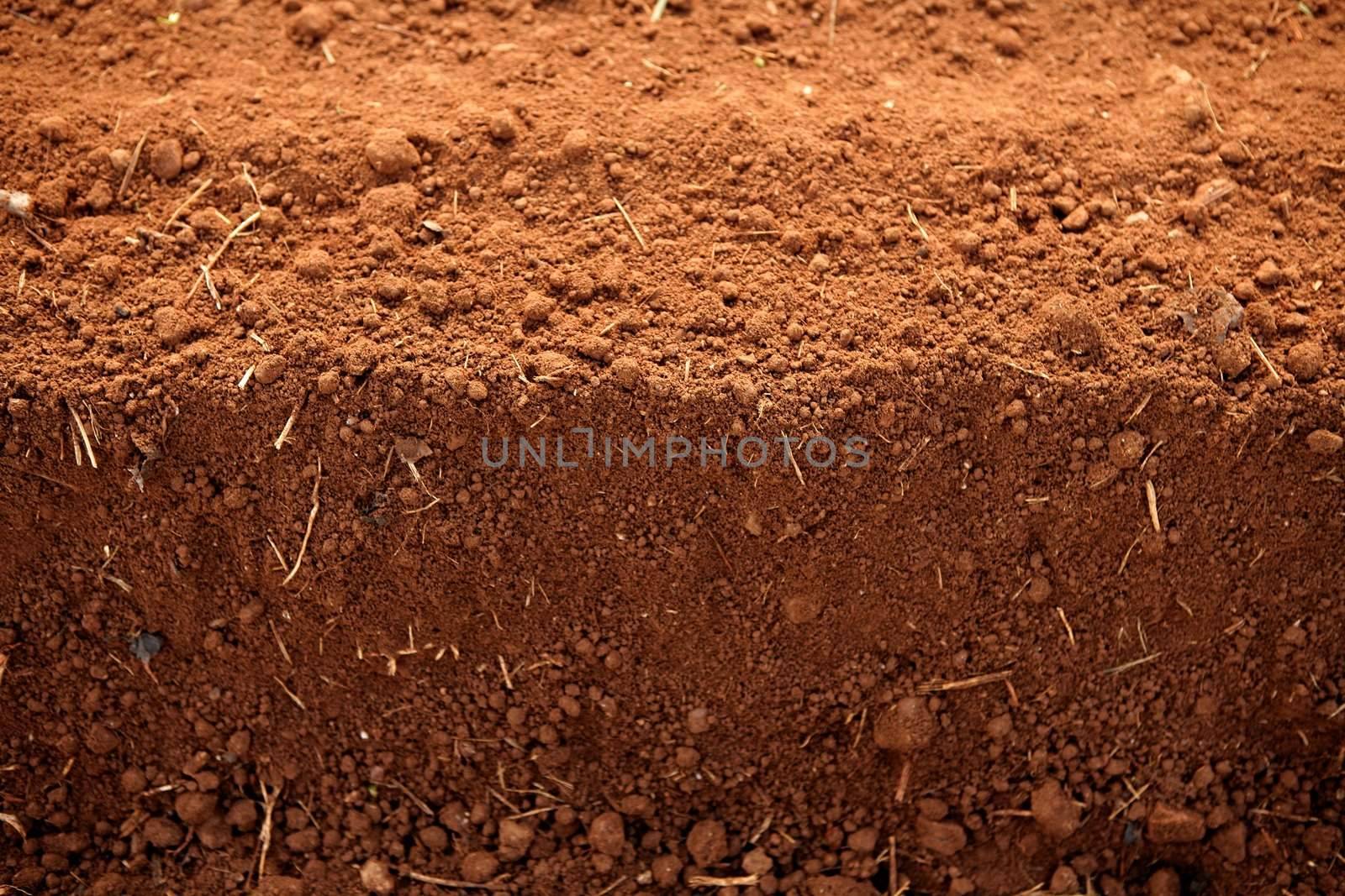 Ploughed red clay soil agriculture fields by lunamarina