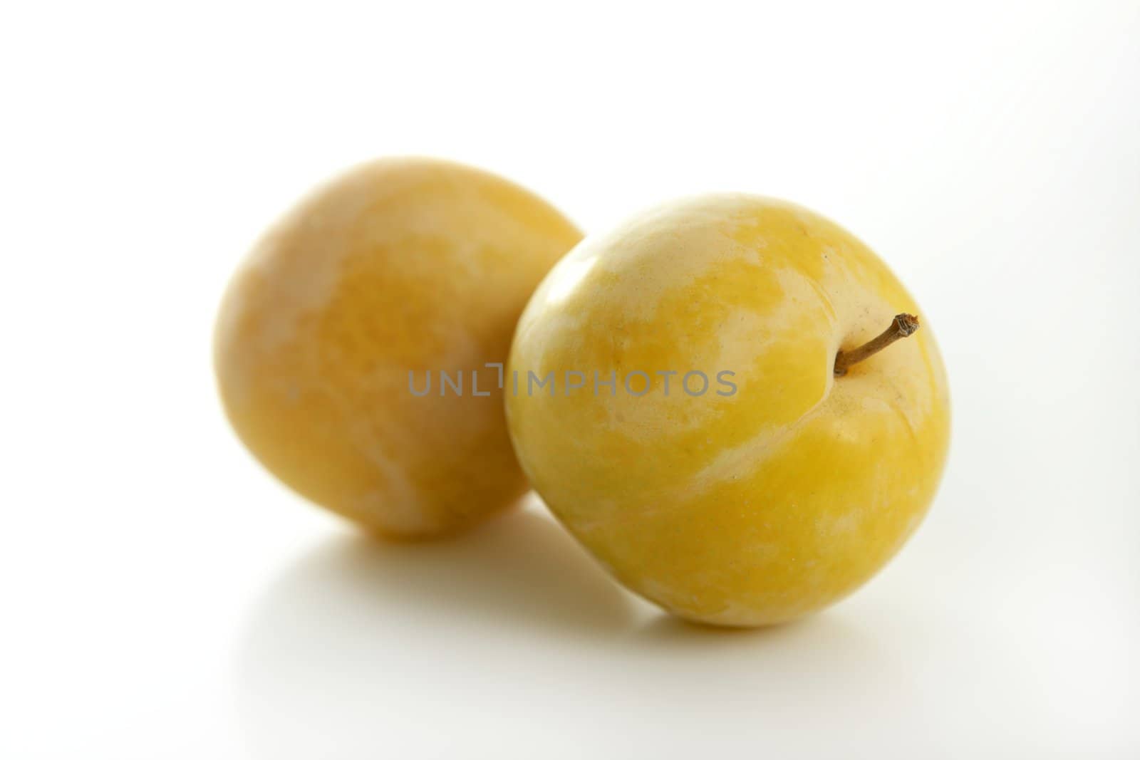 Close up of yellow Mirabelles on white studio background