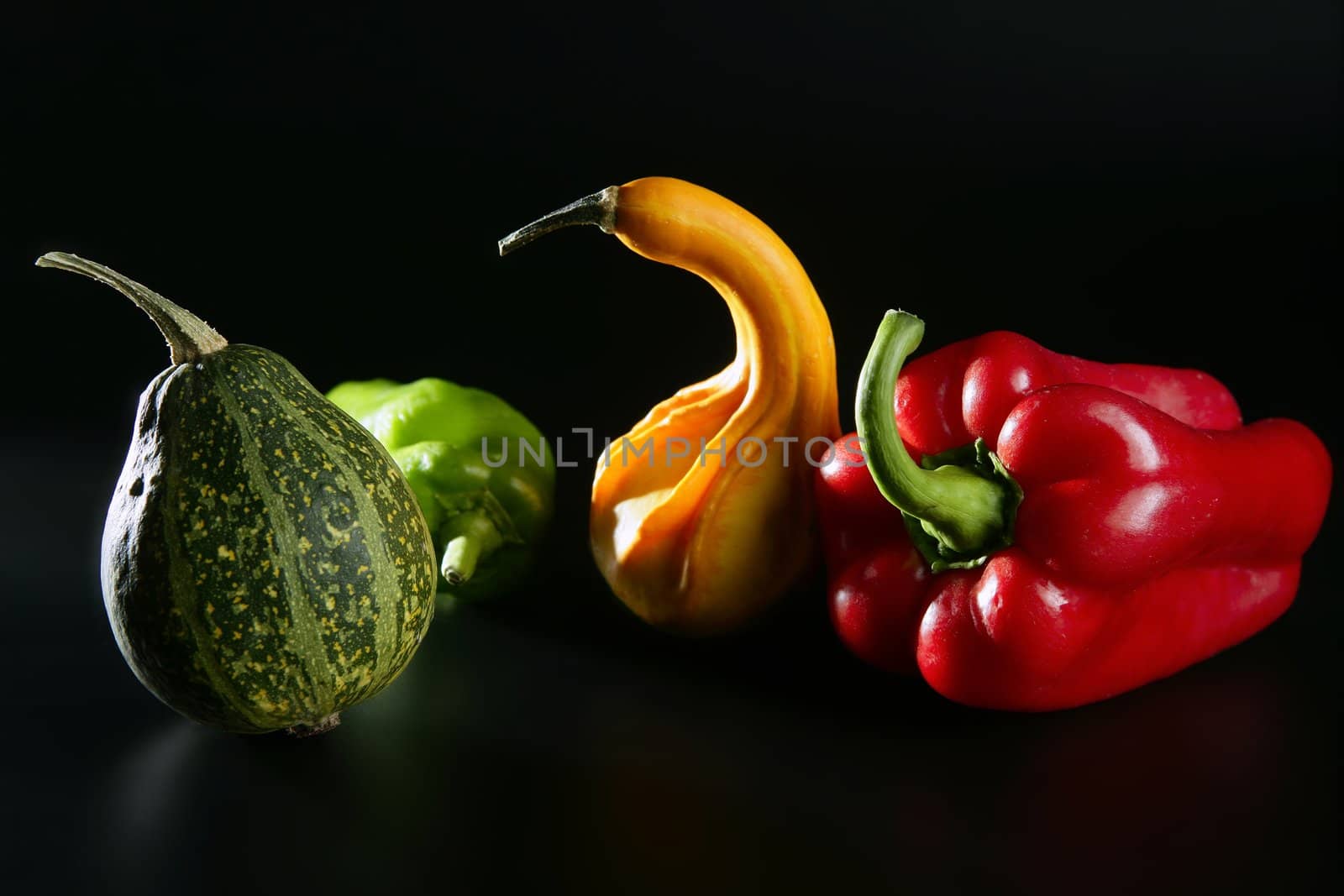 Colorful vegetables still over black, pepper and pumpkin
