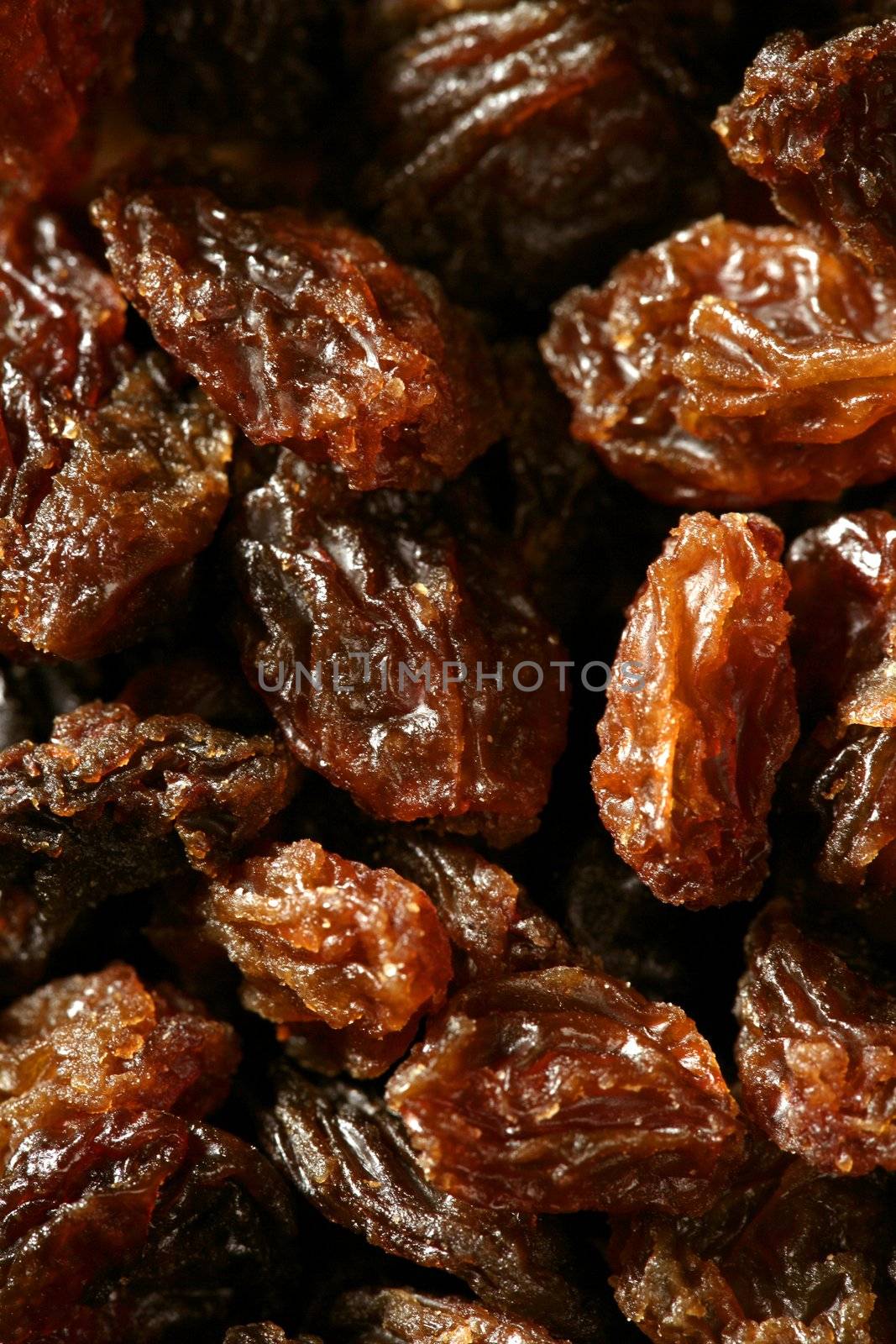 dried raisin macro texture in a close up crop. atural fruits brown background