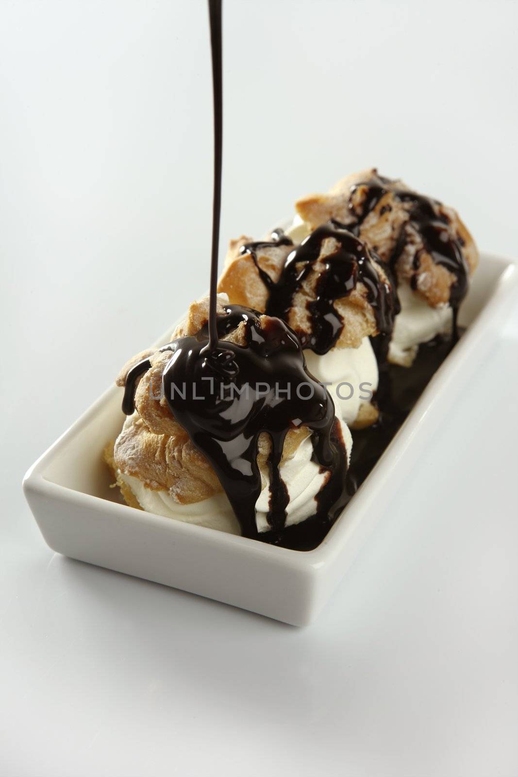 Delicious and addictive cream puff cake dessert with chocolate syrup